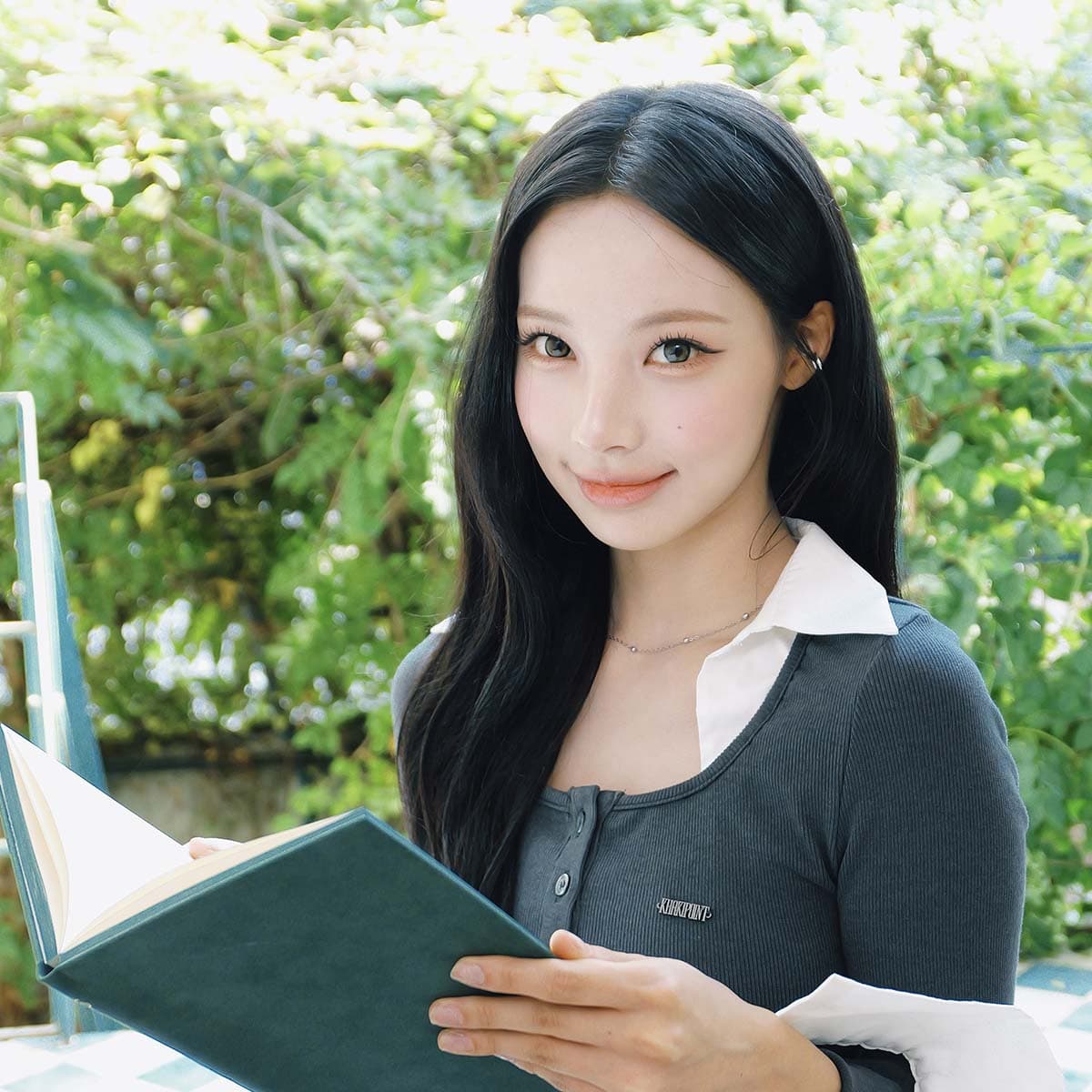 초록 식물 앞에서 짙은 그린 다이어리를 펼친 원이의 공식 상품 사진